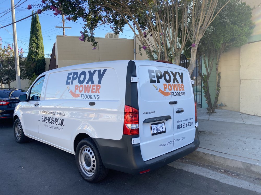 White Epoxy Power Flooring van with blue and orange commercial graphics